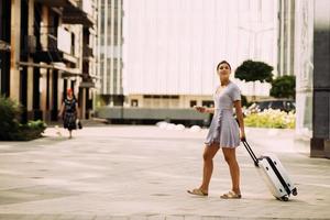 hermosa mujer con maletas cruzando la calle foto