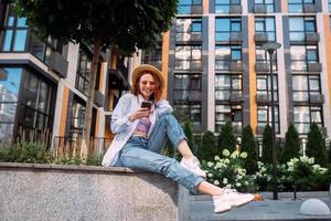 Young lady sitting stairs typing device outside urban city street photo