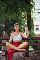 Woman using a smartphone in park sitting on a bench photo