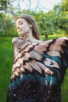 Woman covering shoulders with feathered wing shawl scenic photography photo