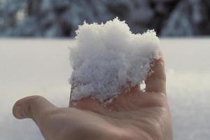 Close up hand with pile of snow concept photo