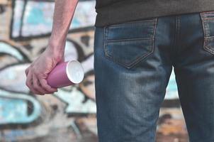 Rear view of a guy drawing a wall with aerosol paint photo