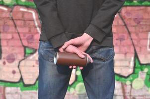 Rear view of a guy drawing a wall with aerosol paint photo