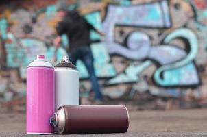 A still-life of several used paint cans of different colors agai photo