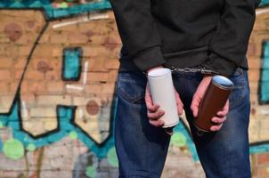 A rear view of an arrested street artist in handcuffs with aeros photo