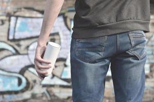 artista de graffiti con una lata de aerosol en la mano. vista trasera foto