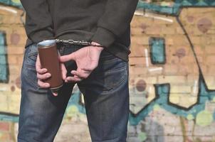 A rear view of an arrested street artist in handcuffs with aeros photo