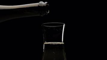 Champagner, Weißwein oder Prosecco in Flöte auf schwarzem Hintergrund in Zeitlupe gießen. alkoholgetränk für party, weihnachtsfeier, jahrestag, geburtstag, silvester video