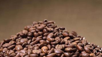 Arabica roasted coffee beans rotating on jute canvas background video