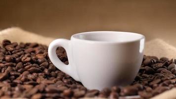 Hot steaming coffee espresso cup and coffee beans video