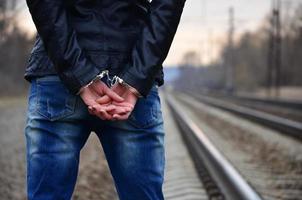 Girl in handcuffs on the background of a railway track photo