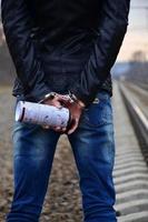 Girl in handcuffs with spraycan on the background of a railway t photo