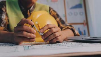 ingénieur en construction travaillant au plan directeur pour construire de grands bâtiments commerciaux au bureau. outils d'ingénierie et concept de construction. video