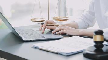 Justice and law concept.Male judge in a courtroom with the gavel, working with, computer and docking keyboard, eyeglasses, on table in morning light video