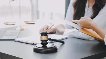 Justice and law concept.Male judge in a courtroom with the gavel, working with, computer and docking keyboard, eyeglasses, on table in morning light video