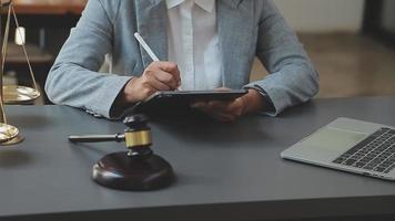 zaken en advocaten bespreken contractpapieren met koperen schaal op bureau in kantoor. wet, juridische diensten, advies, rechtvaardigheid en wet concept foto met film grain effect video