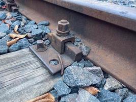 hojas amarillas en el ferrocarril. tiempo de otoño piedras y hojas yacen entre los rieles. rieles de madera y metal, ferrocarril en la ciudad. rieles unidos a pernos pesados foto