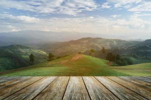 Wooden table terrace and Sunrise landscape with mountain and sun lighting under vibrant colorful morning sky in mountains. Nature mountain sky and clouds sunset concept. photo