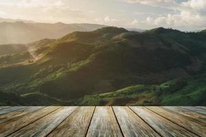 Wooden table terrace and Sunrise landscape with mountain and sun lighting under vibrant colorful morning sky in mountains. Nature mountain sky and clouds sunset concept. photo