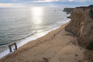 Idyllic view of cliff and beautiful seascape with cloudy sky in the background photo