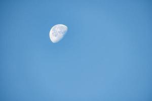 Close up of moon in the morning time with blue sky background photo