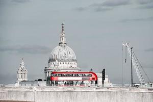 Red double decker bus crossing a bridge in London, England. photo