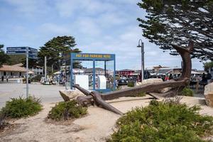 Large old anchor on sand by Kiosks with pay for parking here sign in city photo