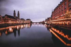 vista de la iglesia de grossmunster al otro lado del río limmit en zurich, suiza foto