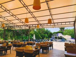 descansar en un hotel caro. cerca de la zona de comedor de la playa para cenar al aire libre. Mobiliario con tapizado en tela y mesas reservadas. lámparas naranjas en el techo foto