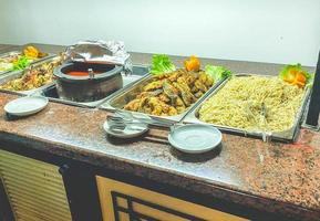 snacks on the table in the hotel. great selection of food for tourists for lunch. spaghetti in a saucepan, dish sauce, meat and mixed vegetables photo