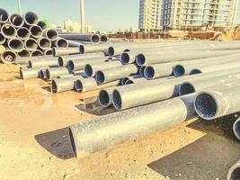 gray PVC tubes plastic pipes stacked in rows. photo