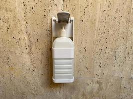 hand sanitizer in the pump bottle hang on the wall photo