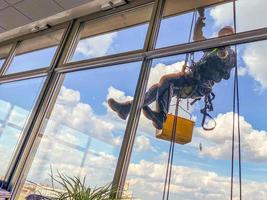 trabajador lavando la ventana en la fachada del edificio. foto