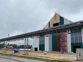 Metal frame of the building with a sandwich panel of insulation on the wall. Construction of a new industrial building. Modern Insulation of the walls of the building panels of insulation photo
