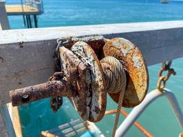 An old rusty winch with an iron rope rope on a reel photo
