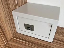 White iron small safe in the hotel room for storing valuables and money photo