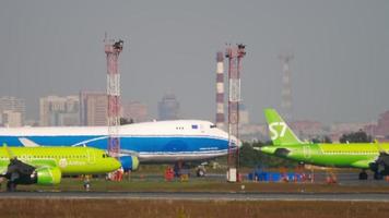 novosibirsk, federación rusa 10 de junio de 2020 - airbus a320 de s7 airlines taxis a la terminal en el aeropuerto internacional tolmachevo, novosibirsk. estacionamiento de aviones en el aeropuerto video