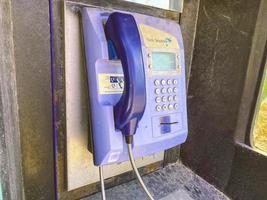 landline phone. blue handset and housing for dialing. phone on the street, public conversation. telephone booth for communication photo
