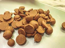 Chocolate callets background. The concept of tempered chocolate confectionery. Cooking chocolates by homemade confectioners. Business idea. close-up and flat lay. photo