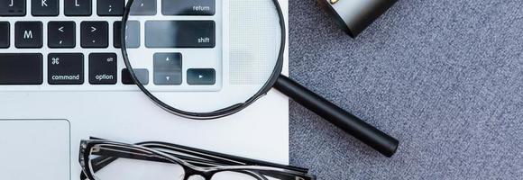 Business summary reports and a magnifying glass with glasses on table office. Concept of Data Analysis, Investment Planning, Business Analytics. photo