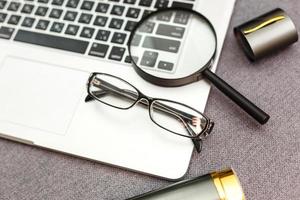 magnifier and glasses on a sheet of paper for business behind blind photo