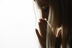 Beautiful redhead freckled young teen girl prays. Close up portrait of a female praying photo