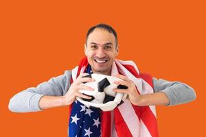 fanático del fútbol con una pelota arrugada deformada y una bandera americana foto