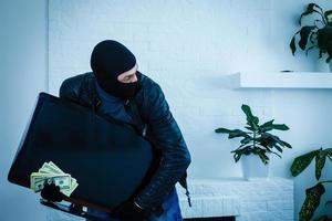 Man burglar stealing tv set from house photo