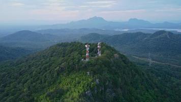 vue aérienne de beaux paysages matinaux avec lever de soleil doré et brouillard coulant avec pylône électrique et structures métalliques sur les sommets des montagnes au-dessus des nuages. technologie et nature en harmonie video