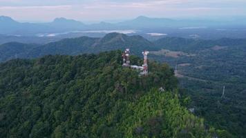 Aerial view of beautiful morning scenery with golden sunrise and fog flowing with electricity pylon and metal structures on mountain peaks high above the clouds. technology and nature in harmony video