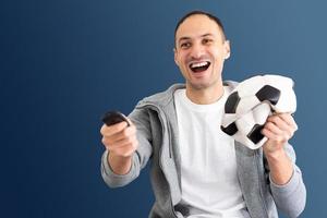 male football fan with a crumpled ball and remote control photo