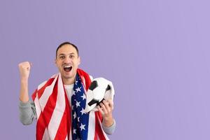 fanático del fútbol masculino con una pelota arrugada y con la bandera de estados unidos foto