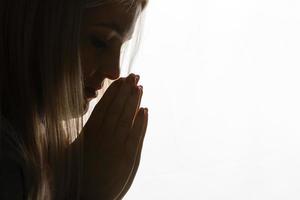 Religious girl praying on background photo