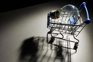 Energy saving light bulb with shopping cart for saving, financial and shopping concept. photo